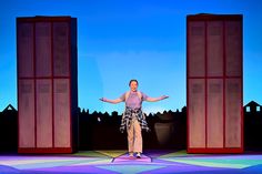 a man standing on top of a stage in front of two tall doors