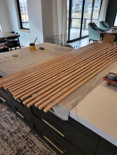 a large bed frame with wooden slats on top of it in a living room