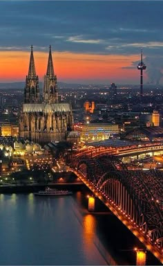 an aerial view of a city at night with lights on and bridges in the foreground