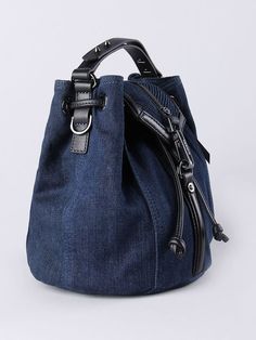 a denim bag with zippers on the front and side, sitting against a white background