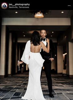 a man in a tuxedo standing next to a woman in a white dress