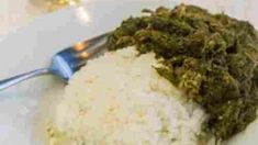 a white plate topped with rice and greens