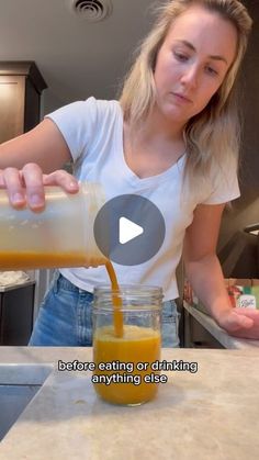 a woman pouring orange juice into a jar