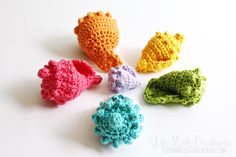 four crocheted sea animals sitting on top of a white table