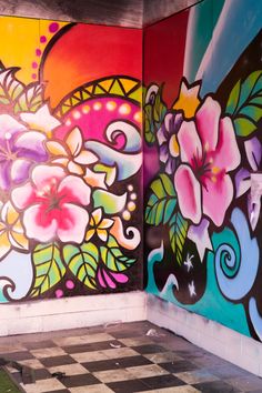 the wall is painted with colorful flowers and swirls on it, along with black and white checkered flooring