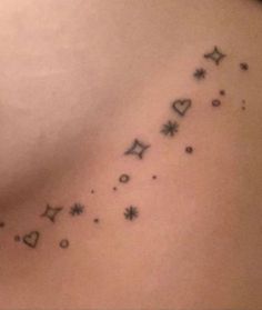 the back of a woman's shoulder with small stars and hearts on her left side