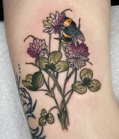 a tattoo with flowers and a bird on it