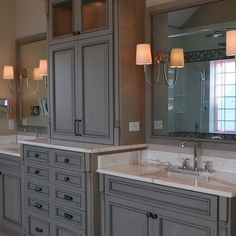 a large bathroom with two sinks and three mirrors on the wall next to each other