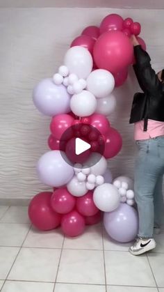 a woman standing next to a giant balloon letter