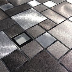 a close up view of a tiled surface with an electronic device in the center,