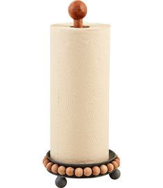 a roll of toilet paper sitting on top of a wooden holder with beads around it