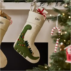 two christmas stockings hanging from a mantel