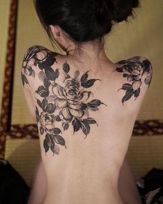 the back of a woman's body with flowers on it