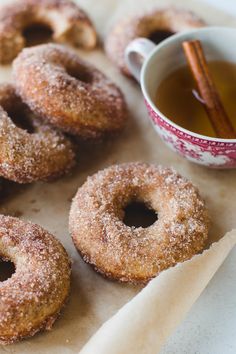 cinnamon sugar donuts and cup of tea with cinnamon sticks on the side, ready to be eaten