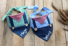 two bibs with ties on them sitting on a wooden floor