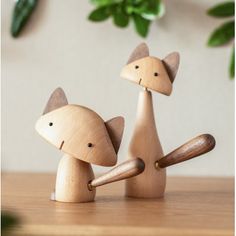 two wooden toy foxes sitting on top of a table