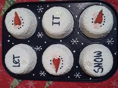 four cupcakes with frosting on them in a muffin pan that says it's christmas