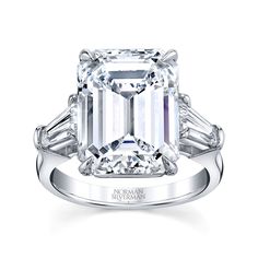 an emerald - cut diamond ring with baguets on the shoulders and side stones