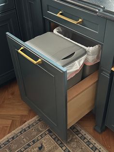 an open trash can in the middle of a kitchen