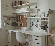 a white desk with lots of drawers and shelves on top of it in front of a window