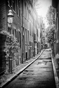 an empty street lined with tall brick buildings