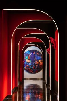 an art piece is displayed in the middle of a room with red walls and arches