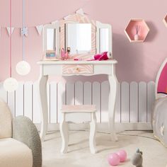 a bedroom with pink walls and furniture in the corner, including a white vanity table