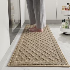 a person standing on top of a rug in a kitchen