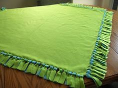 a table with a green blanket on top of it and blue trim around the edges