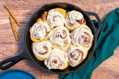 a pan filled with cinnamon rolls on top of a wooden table