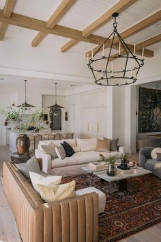 a living room filled with furniture and a chandelier hanging over the top of it