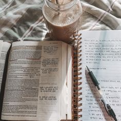 an open book sitting on top of a bed next to a jar of chocolate milk