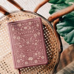 a pink book sitting on top of a wooden chair