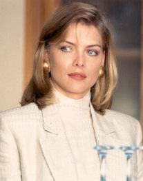 a woman sitting at a table with a glass of water in front of her and looking off to the side