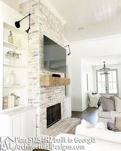 a living room filled with furniture and a flat screen tv mounted on a brick wall