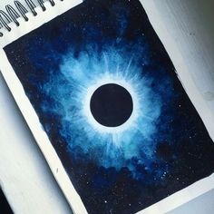 a spiral notebook with an image of a black hole in the center