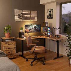 a room with a desk, chair and pictures on the wall above it is also a bed