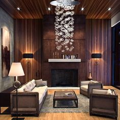 a living room filled with furniture and a chandelier hanging from the ceiling over a fire place