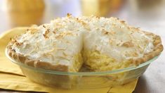 a pie sitting on top of a yellow napkin next to a glass bowl filled with food