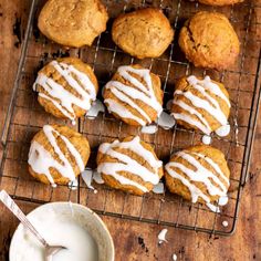 freshly baked cookies with icing on a cooling rack next to a cup of coffee