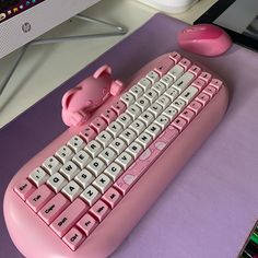 a pink computer keyboard sitting on top of a desk