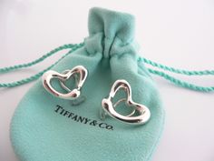 Some people wear their hearts on their sleeves ... I suggest you show off your shiny heart on your ears! :) Offered for sale is a wonderful pair of Tiffany and Co. Silver Peretti Large Open Heart Clip On earrings. The earrings are made from solid Tiffany silver, yet maintains a very feminine and delicate feel to it . These earrings look great with almost any attire one can think of - it can go from a day on the beach in shorts to a night out of town - no changing necessary. The style is classic Tiffany And Co Earrings, Heart Clip, Rare Gifts, Tiffany And Co, Gift Pouch, Open Heart, Stunning Jewellery, Heart On, Tiffany Heart