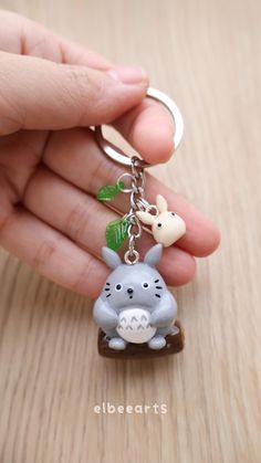 a hand holding a keychain with a rhino and giraffe on it