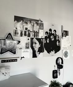 black and white photograph of the wall in an office with many pictures on it, including a clock