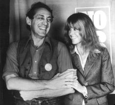 an old black and white photo of a man and woman posing for the camera with their arms around each other