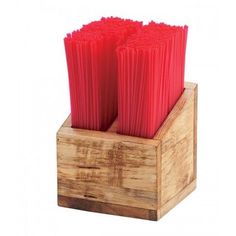 three red candles are in a wooden holder