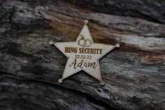 a star shaped pin with the words ring security on it sitting next to a tree