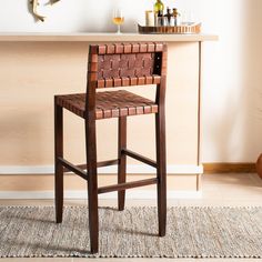 a brown leather bar stool sitting on top of a rug next to a wooden counter