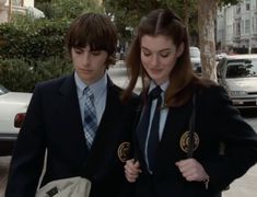 two people in suits and ties walking down the street