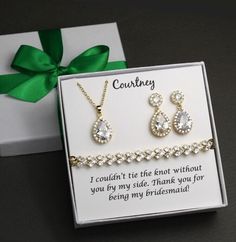 two pieces of jewelry in a gift box with a green bow on the side and card saying, i couldn't tie the knot without you by my side thank you for being my bridesmaid